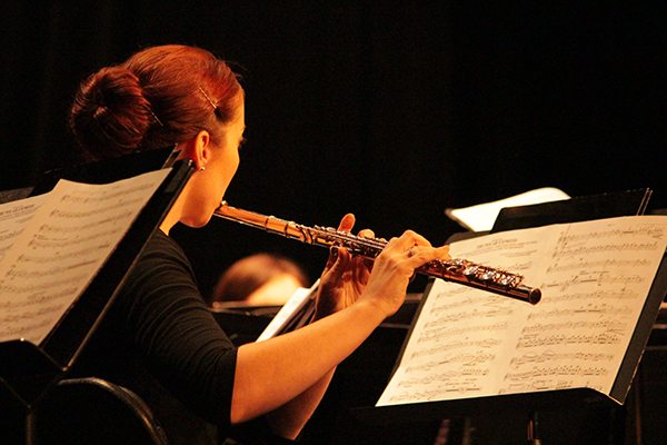 Female student plays music on a flute